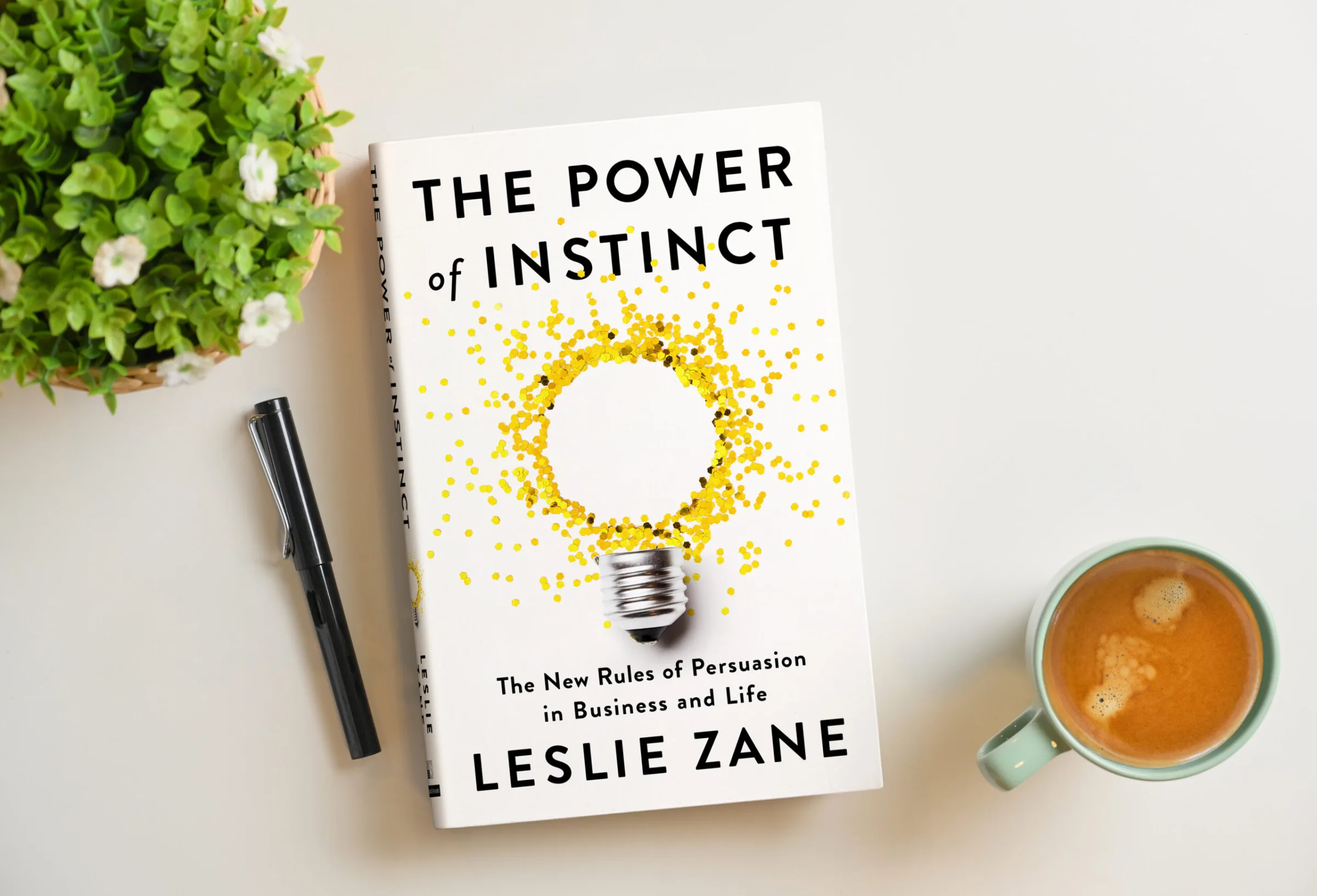 The Power of Instinct on a desk, beside a pen and a cup of coffee