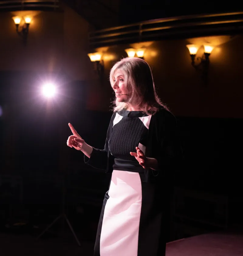 Leslie Zane speaking on a theatre stage