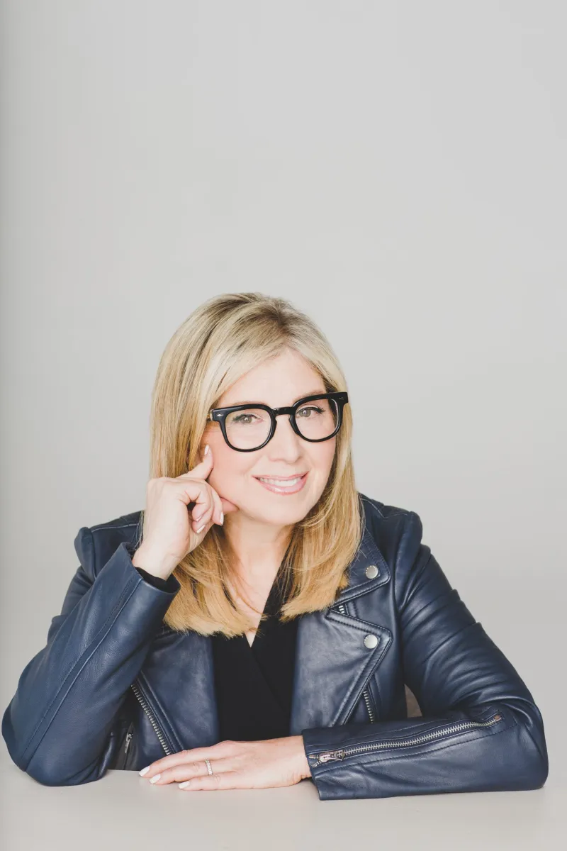 Leslie Zane in a leather jacket and glasses